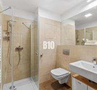 1-IZBOVÝ BYT S VEĽKOU 12 m² TERASOU | SLNEČNICE VILADOMY - Kúpeľňa s toaletou, sprchovým kútom a umývadlom v 1-izbovom byte.