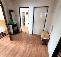 3-IZBOVÝ BYT 90 m² V RODINNOM DOME | POVAŽSKÝ CHLMEC - Žilina - Interiér rodinného domu s podlahou s dreveným dekorom, krbom a dveřami do iných miestností.