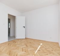 NA PREDAJ-3-IZBOVÝ BYT-NOVÁ REKONŠTRUKCIA-UL.POKROKU-KOŠICE-ZÁPAD - Izba s bielymi stenami, podlahou s dreveným dekorom v 3-izbovom byte.