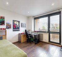 BENADOVA - 4-IZBOVÝ BYT PO KOMPLETNEJ REKONŠTRUKCII, 79 m², LOGGIA  - Detská izba s veľkými oknami, komiksovými plagátmi a podlahou s dreveným dekorom.