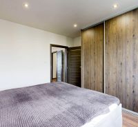 BENADOVA - 4-IZBOVÝ BYT PO KOMPLETNEJ REKONŠTRUKCII, 79 m², LOGGIA  - Spálňa v 4-izbovom byte s posuvnou skriňou a podlahou s dreveným dekorom.