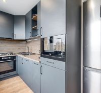 BENADOVA - 4-IZBOVÝ BYT PO KOMPLETNEJ REKONŠTRUKCII, 79 m², LOGGIA  - Kuchyňa v 4-izbovom byte s modernou výbavou a podlahou s dreveným dekorom.