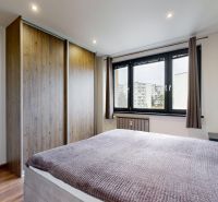 BENADOVA - 4-IZBOVÝ BYT PO KOMPLETNEJ REKONŠTRUKCII, 79 m², LOGGIA  - Spálňa v 4-izbovom byte s podlahou s dreveným dekorom, šatníkovou skriňou a oknom.