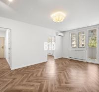 Prémiové bývanie v centre Nitry | 3 izby, veľký balkón - Obývacia izba v 3-izbovom byte so vzorovanou podlahou s dreveným dekorom.