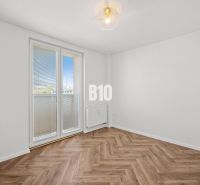Prémiové bývanie v centre Nitry | 3 izby, veľký balkón - Prázdna izba s podlahou s dreveným dekorom a balkónovými dverami v 3-izbovom byte.