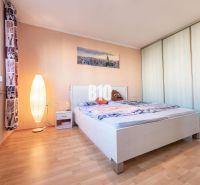 REZERVOVANÉ_1 izb. byt s veľkým balkónom | Klokočina - Nitra - Spálňa s podlahou s dreveným dekorom, posteľou a skriňou v 1-izbovom byte.