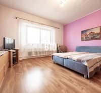Prerobený dom, 981 m2 pozemok - Chrenová, Nitra (TOP lokalita) - Spálňa v rodinnom dome s podlahou s dreveným dekorom, nábytkom a televízorom.