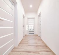 5 izb. bungalov s bazénom, garáž, RED OAK - Nitra, Lužianky - Svetlá chodba v rodinnom dome s podlahou s dreveným dekorom a bielymi dverami.
