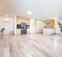 5 izb. bungalov s bazénom, garáž, RED OAK - Nitra, Lužianky - Interiér rodinného domu s podlahou s dreveným dekorom a modernou kuchyňou.