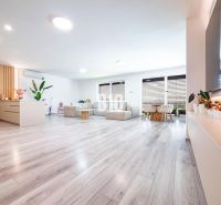 5 izb. bungalov s bazénom, garáž, RED OAK - Nitra, Lužianky - Priestranná obývacia izba s podlahou s dreveným dekorom a veľkým sedením v rodinnom dome.