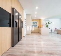 5 izb. bungalov s bazénom, garáž, RED OAK - Nitra, Lužianky - Priestranná obývacia izba s podlahou s dreveným dekorom v rodinnom dome.