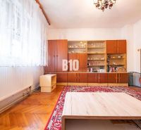 DOM, 1439 m2 pozemkom - Zbehy, Nitra (investičný potenciál) - Obývacia izba s prehľadnou vitrínou, podlahou s dreveným dekorom a červeným kobercom v rodinnom dome.