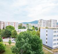Nový 3 izb. byt s 2x balkónom, Nitra - Chrenová (2026) - Výhľad z 3-izbového bytu v Nitre na panelové domy a parkovisko s automobilmi.