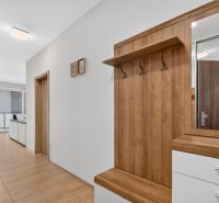 Predaj 2-izbový byt GREEN VILLAGE, loggia, parkovanie, Dunajská Lužná - Vstupná chodba v 2-izbovom byte s podlahou s dreveným dekorom a vešiakovou stenou.