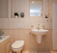LAURINSKÁ, 2i byt, 68m² – REPREZENTATÍVNE bývanie v historickom CENTRE - Kúpeľňa v 2-izbovom byte s vaňou, umývadlom a toaletou, béžové obklady a dekorácie.