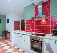 LAURINSKÁ, 2i byt, 68m² – REPREZENTATÍVNE bývanie v historickom CENTRE - Kuchyňa v 2-izbovom byte s červeným obkladom a jedálenským stolom.