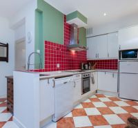 LAURINSKÁ, 2i byt, 68m² – REPREZENTATÍVNE bývanie v historickom CENTRE - Kuchyňa v 2-izbovom byte s červenými obkladmi a dlažbou v šachovnicovom vzore.
