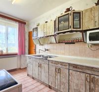 Predaj rodinného domu, Na Vrších, Na Vrších, Benešov - Kuchyňa v rodinnom dome s pestrou záclonou, dlažbou a kuchynskou linkou.
