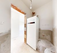 Skolaudovaný 4 izbový RD bungalov 101,65 m2 na pozemku 531 m2, Senec - Miesto v rodinnom dome s bielym spotrebičom a nedokončenými stenami.