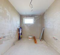 Skolaudovaný 4 izbový RD bungalov 101,65 m2 na pozemku 531 m2, Senec - Nedokončená kúpeľňa v rodinnom dome s oknom a prípravou na inštaláciu sanity.