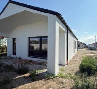 Skolaudovaný 4 izbový RD bungalov 101,65 m2 na pozemku 531 m2, Senec - Rodinný dom na Karasovej ulici v Senci s jednoduchým bielym exteriérom a okolím.