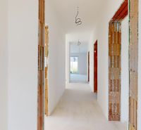 Skolaudovaný 4 izbový RD bungalov 101,65 m2 na pozemku 531 m2, Senec - Chodba v rodinnom dome pripravená na dokončenie, s pohľadom do záhrady.