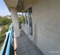 Slnečný 2-izb. byt, Račianske mýto, lodžia, výhľad do parku - Balkón 2-izbového bytu s modrým zábradlím a výhľadom na zeleň v Bratislave.