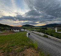 REZERVOVANÉ : Na predaj pozemok v obci Stožok – lokalita Pod Chvojnom - Panoráma obce Stožok so západom slnka a pozemkami na bývanie v kopcovitej krajine.