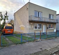 Rodinný dom vo vyhľadávanej lokalite!! - Rodinný dom v Senici s rovnou strechou, balkónom a zaparkovaným oranžovým autom.