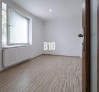 3 IZBOVÝ BYT V KOMORNEJ TEHLOVEJ BYTOVKE | TOPOĽČANY - Prázdna miestnosť s podlahou s dreveným dekorom v 3-izbovom byte.