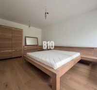 Relax Residence - Apartmán so zariadením - Spálňa v 2-izbovom byte s dreveným nábytkom a podlahou s dreveným dekorom.