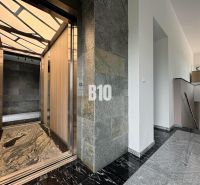 Relax Residence - Apartmán so zariadením - Chodba so štýlovým výťahom v 2-izbovom byte, kamennými stenami a podlahou.