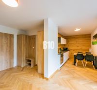 Investičný APARTMÁN v centre Terchovej - Kuchyňa a jedálenský priestor v rekreačnom apartmáne s podlahou s dreveným dekorom.