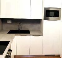 Na prenájom 2-izb byt vo výškovej novostavbe -  Matadorka - Biela kuchyňa s mikrovlnkou a zabudovaným drezom, 2-izbový byt, podlaha s dreveným dekorom.