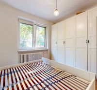 Priestranný 2i byt v obklopení zelene len pár krokov od OC Nivy | 53m² - Spálňa s posteľou, vstavanou skriňou a podlahou s dreveným dekorom v 2-izbovom byte.