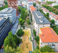 Priestranný 2i byt v obklopení zelene len pár krokov od OC Nivy | 53m² - Letecký pohľad na Budovateľskú ulicu v Bratislave - Ružinove s bytovými domami a ihriskom.