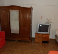 Dvojizbový byt v rodinnom dome v Seredi na prenájom  - Izba v 2-izbovom byte s dreveným nábytkom a podlahou s dreveným dekorom.