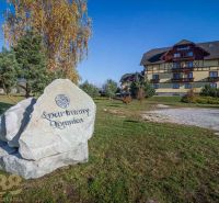 Na predaj: 2-izbový byt s garážou pod Vysokými Tatrami  - Apartmánový komplex vo Veľkej Lomnici, na trávnatej ploche s veľkým kamenným nápisom.