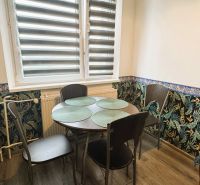 94,66 m², štyri izby a nikto nad hlavou. A Komenského má svoje výhody! - Jedálenský kút v 4-izbovom byte s kvetinovou tapetou a stolom pre štyroch.