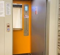 94,66 m², štyri izby a nikto nad hlavou. A Komenského má svoje výhody! - Otvorený výťah v budove 4-izbového bytu s oranžovým interiérom.