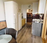 94,66 m², štyri izby a nikto nad hlavou. A Komenského má svoje výhody! - Kuchyňa v 4-izbovom byte s podlahou s dreveným dekorom, jedálenským stolom a spotrebičmi.