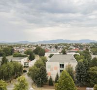 94,66 m², štyri izby a nikto nad hlavou. A Komenského má svoje výhody! - Pohľad na Komenského ulicu v Trebišove s budovami a zeleňou.