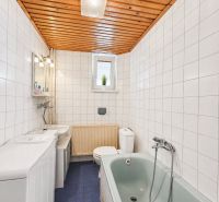 Rodinný dom v okrese Košice - okolie, Nižná Hutka - Kúpeľňa s obkladmi, modrou podlahou, vaňou a dreveným stropom v rodinnom dome.