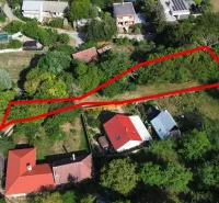Kolačno – 90 m2 INVESTIČNÝ pozemok v obci - Predaj - Letecký pohľad na pozemok v záhradách v Kolačne, obklopený zeleňou a domami.