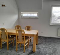 Prenájom dvoch 2-izbových bytov vedľa seba, Martin - centrum - Stôl so štyrmi stoličkami v 2-izbovom byte, sivý koberec, dve okná.