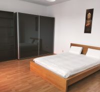 Prenájom dvoch 2-izbových bytov vedľa seba, Martin - centrum - Spálňa v 2-izbovom byte s posteľou a veľkou šatníkovou skriňou, podlaha s dreveným dekorom.