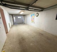 Ponúkam na predaj veľký 4i rodinný dom v tichej slepej ulici - Garáž v rodinnom dome s mapou a hodinami na stene.