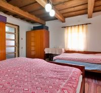 Rezervované - Tradičná drevenica s potenciálom v Žabokrekoch - Spálňa v rodinnom dome s dreveným stropom, skrinkami a svietidlom.