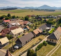 Rezervované - Tradičná drevenica s potenciálom v Žabokrekoch - Žabokreky: Panoráma rodinných domov s vidieckym charakterom a kopcami v pozadí.