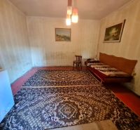 RD Otrokovce 1071m pozemok - Izba v rodinnom dome s kobercom, stoličkou a gaučom.